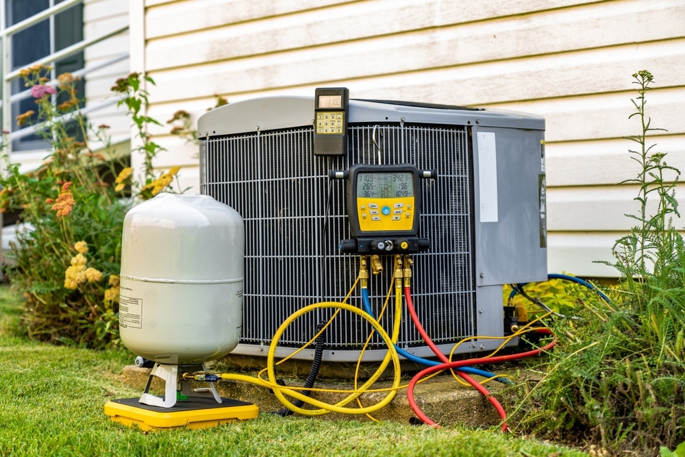 An old air conditioning unit that is being repaired by an HVAC service technician. 