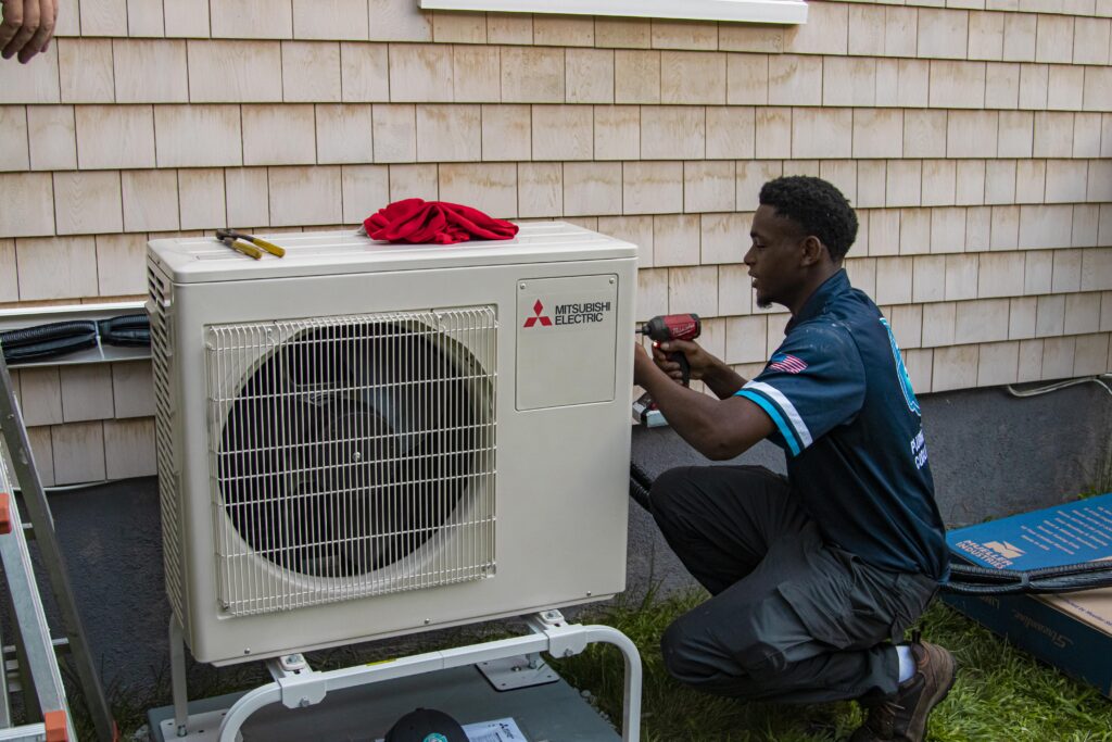 A view of a technician fixing an AC outer heat pump 