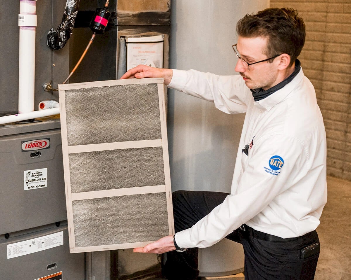 A technician changing a furnace filter