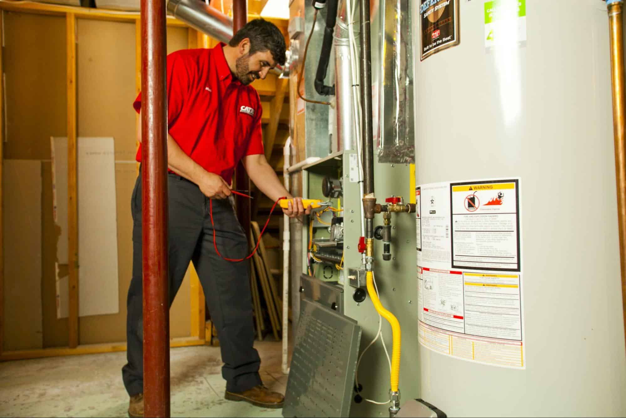 Technician testing furnace and water heater system during maintenance or installation